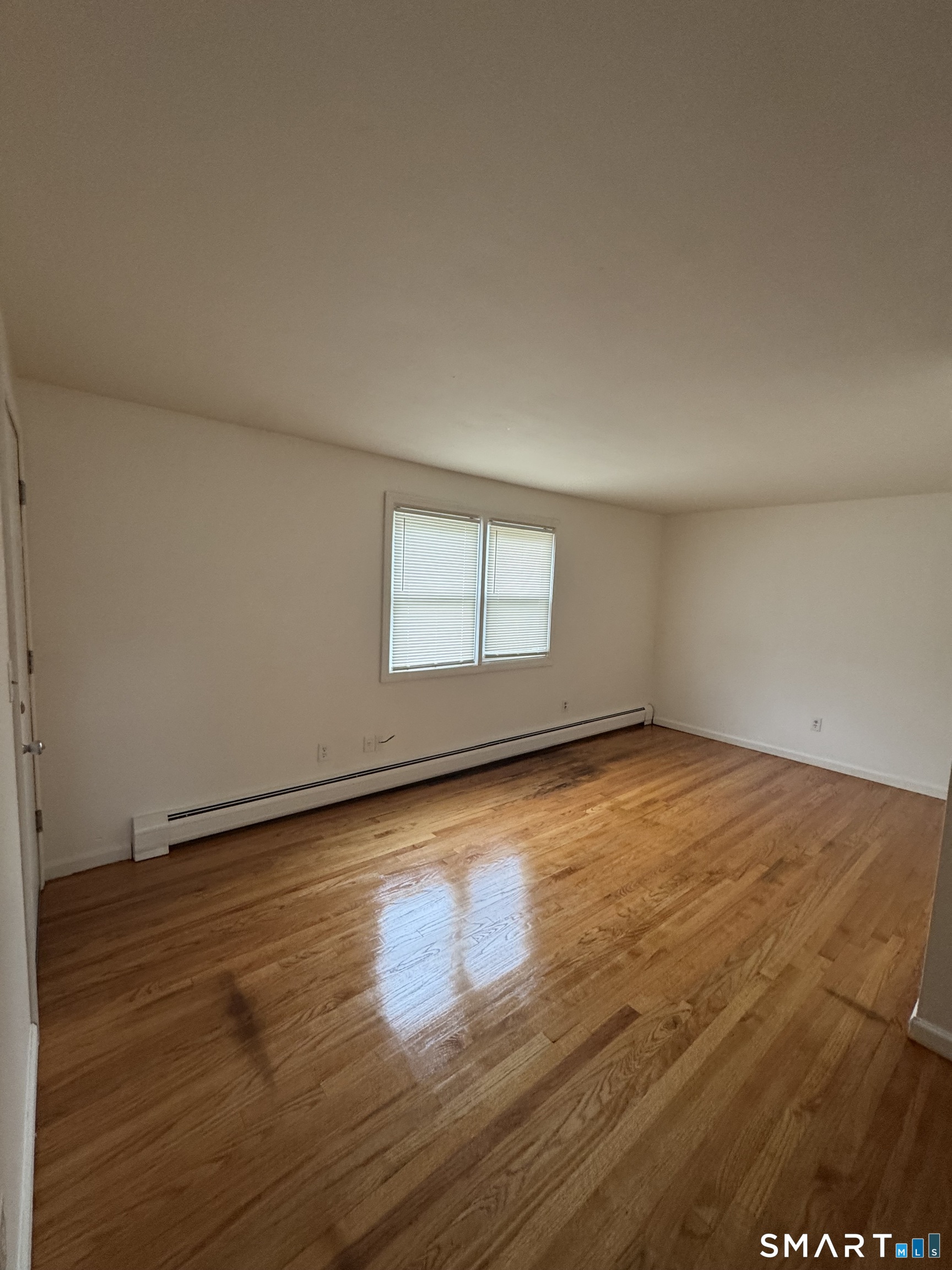 68 Warner Street, Unit B2 Hamden, CT 06514 - Photo 3 of 6 an empty room with wooden floor and windows