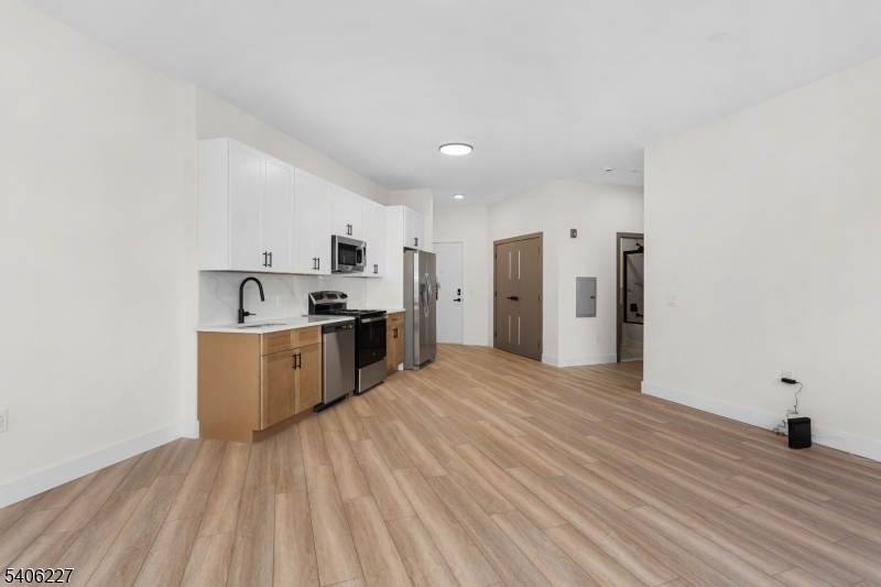 87-89 Mary Street, Unit 504 Paterson, NJ 07503 - Photo 3 of 10 a view of kitchen with stainless steel appliances granite countertop a stove a sink dishwasher and a refrigerator with wooden floor