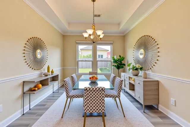 a living room with furniture a chandelier and a dining table
