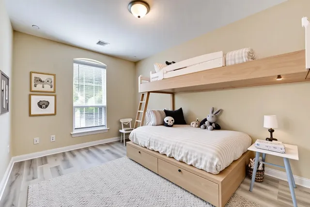 a bedroom with a bed and wooden floor