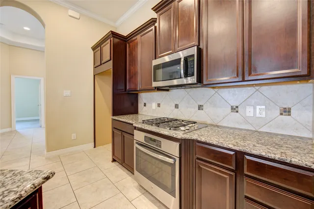 a kitchen with stainless steel appliances granite countertop a stove microwave and refrigerator
