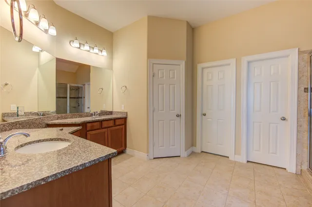 a spacious bathroom with a granite countertop sink and a mirror
