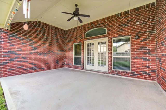 a view of an empty room with a window and a ceiling fan