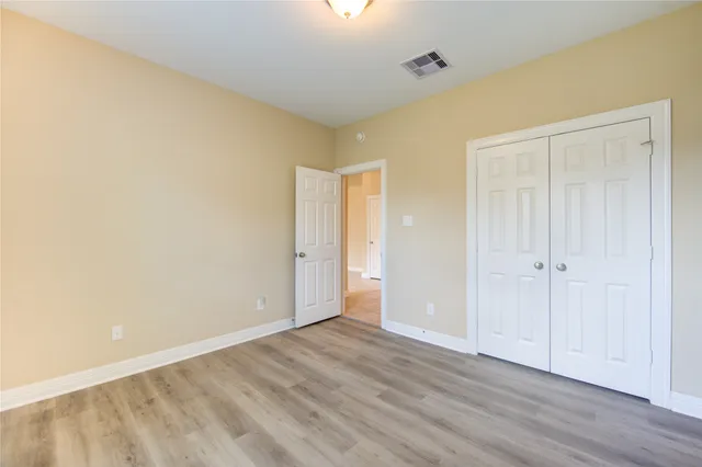 a view of an empty room with wooden floor