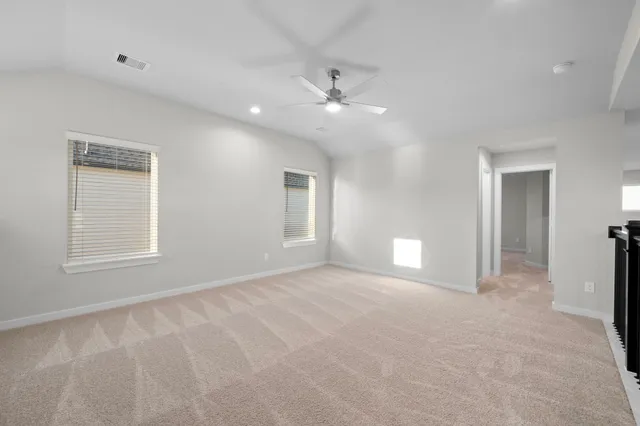 an empty room with windows and ceiling fan