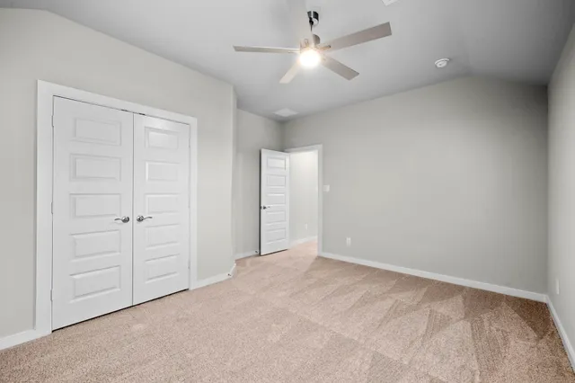 an empty room with a ceiling fan and a window
