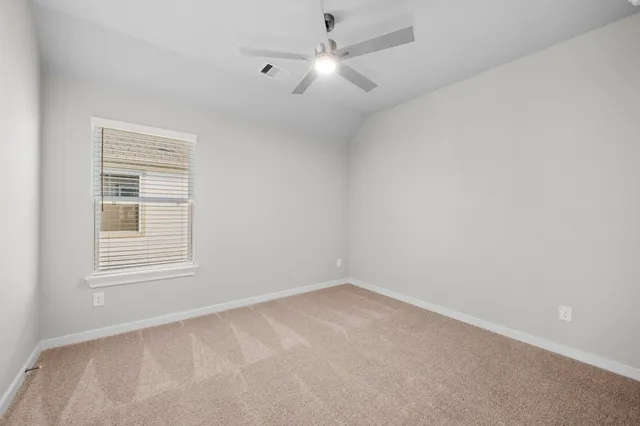 an empty room with a window and a fan