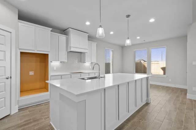 a kitchen with kitchen island a white counter top space a sink and appliances