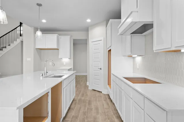 a kitchen with kitchen island white cabinets stainless steel appliances a sink and a center island