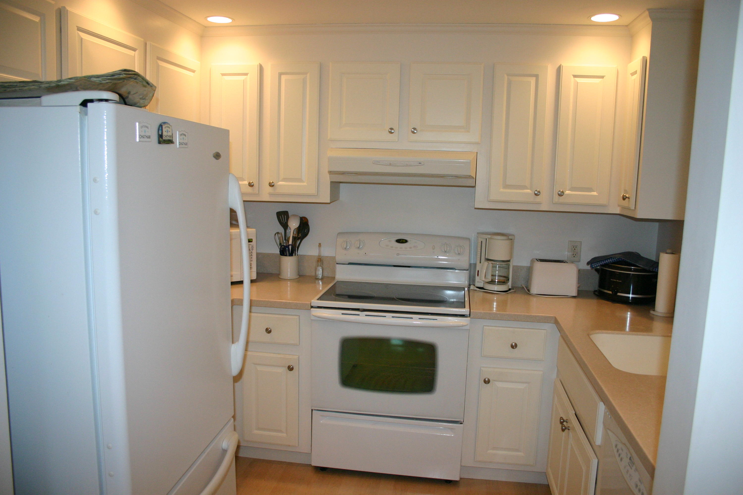 93 Depot Road, Unit 10 Chatham, MA 02633 - Photo 13 of 16 a kitchen with stainless steel appliances white cabinets and a refrigerator