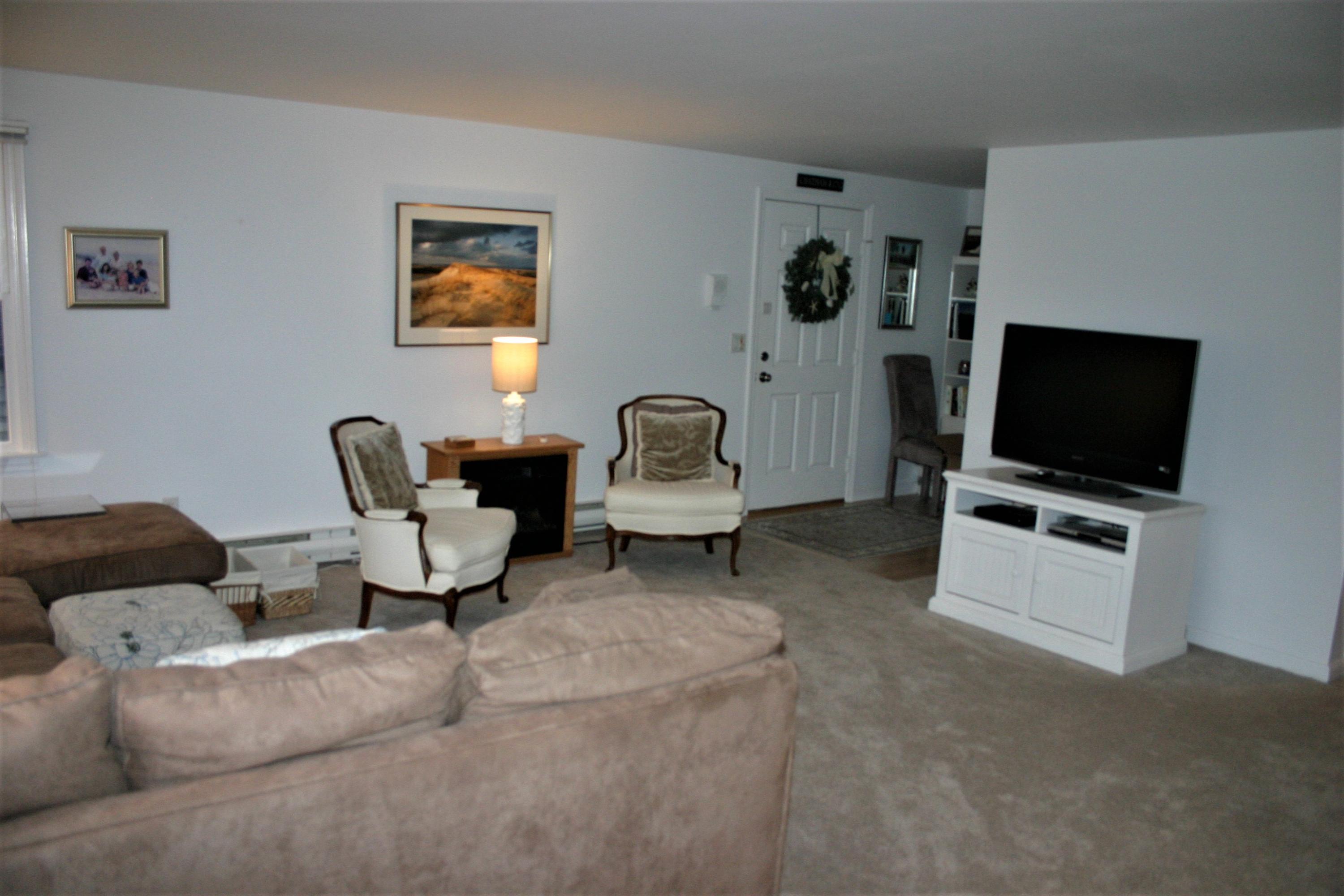 93 Depot Road, Unit 10 Chatham, MA 02633 - Photo 5 of 16 a living room with furniture and a flat screen tv