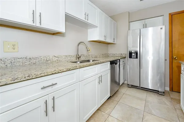 a kitchen with stainless steel appliances granite countertop a refrigerator and a sink