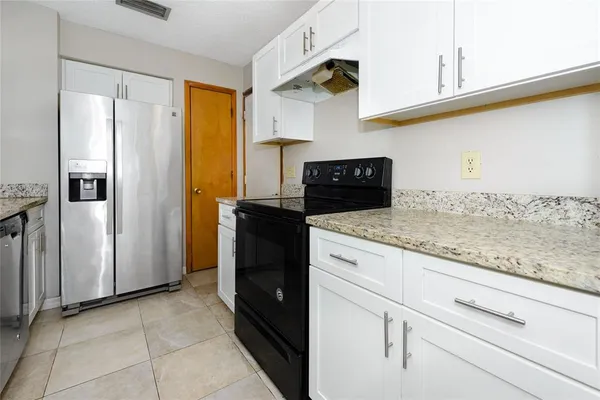 a kitchen with granite countertop a refrigerator and a stove