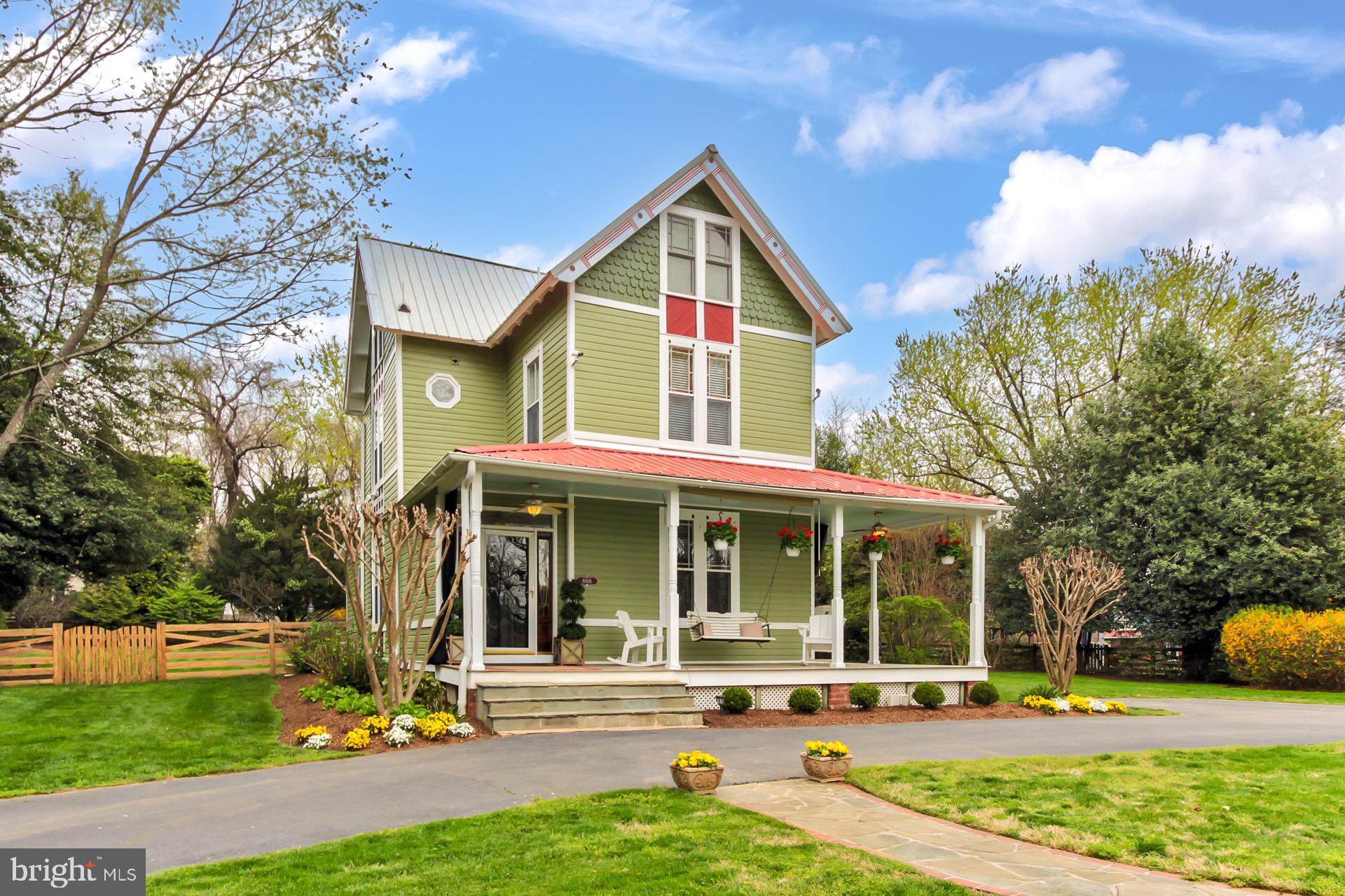 a front view of a house with garden and trees