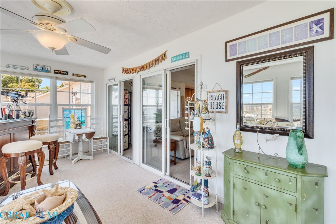 13 Leming Avenue Reedville, VA 22539 - Photo 18 of 50 Carpeted sunroom featuring a ceiling fan with integrated lighting, multiple windows, and two sets of sliding glass doors