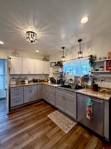 a kitchen with stainless steel appliances granite countertop a stove cabinets and wooden floor
