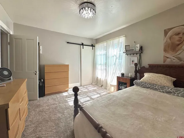 a bedroom with a bed and a chandelier