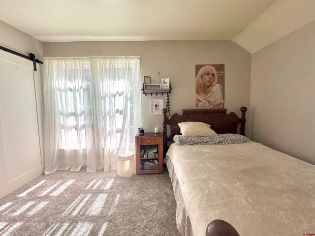 a spacious bedroom with a bed and a window