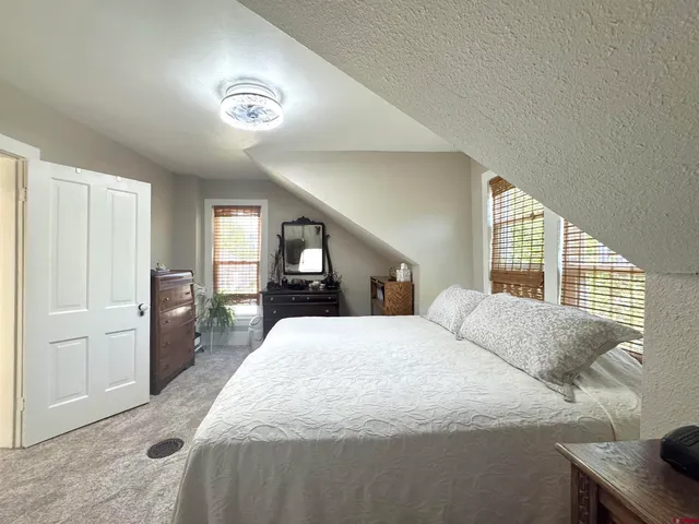 a spacious bedroom with a large bed and a chandelier