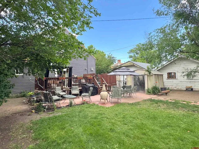 a view of a patio with table and chairs under an umbrella
