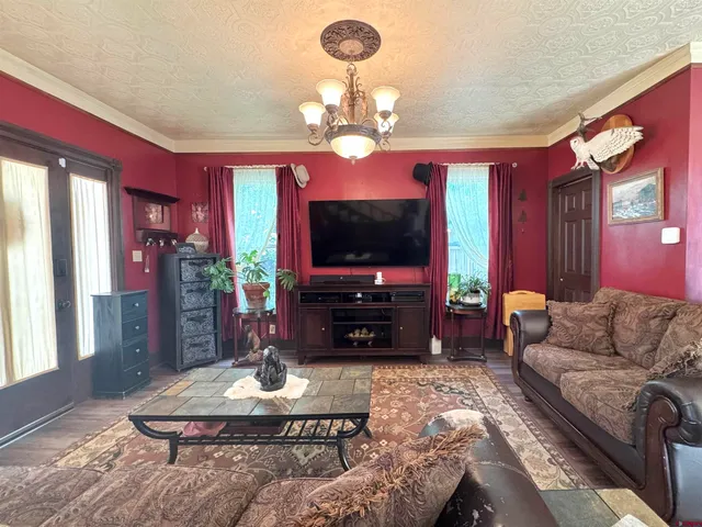 a living room with furniture a flat screen tv and a chandelier