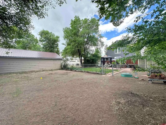 a view of backyard of house with green space