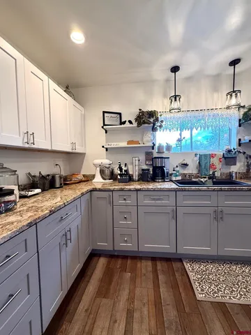 a kitchen with a sink cabinets and wooden floor