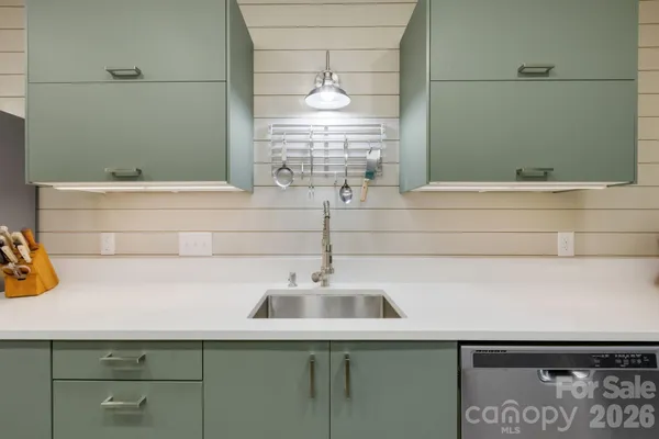 a living room with furniture a flat screen tv and kitchen view