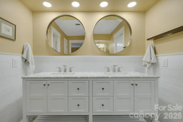 a bathroom with a granite countertop double vanity sink and a mirror