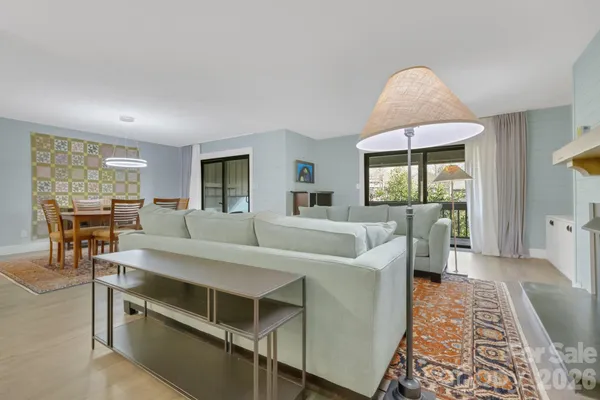 a living room with furniture a flat screen tv and a table
