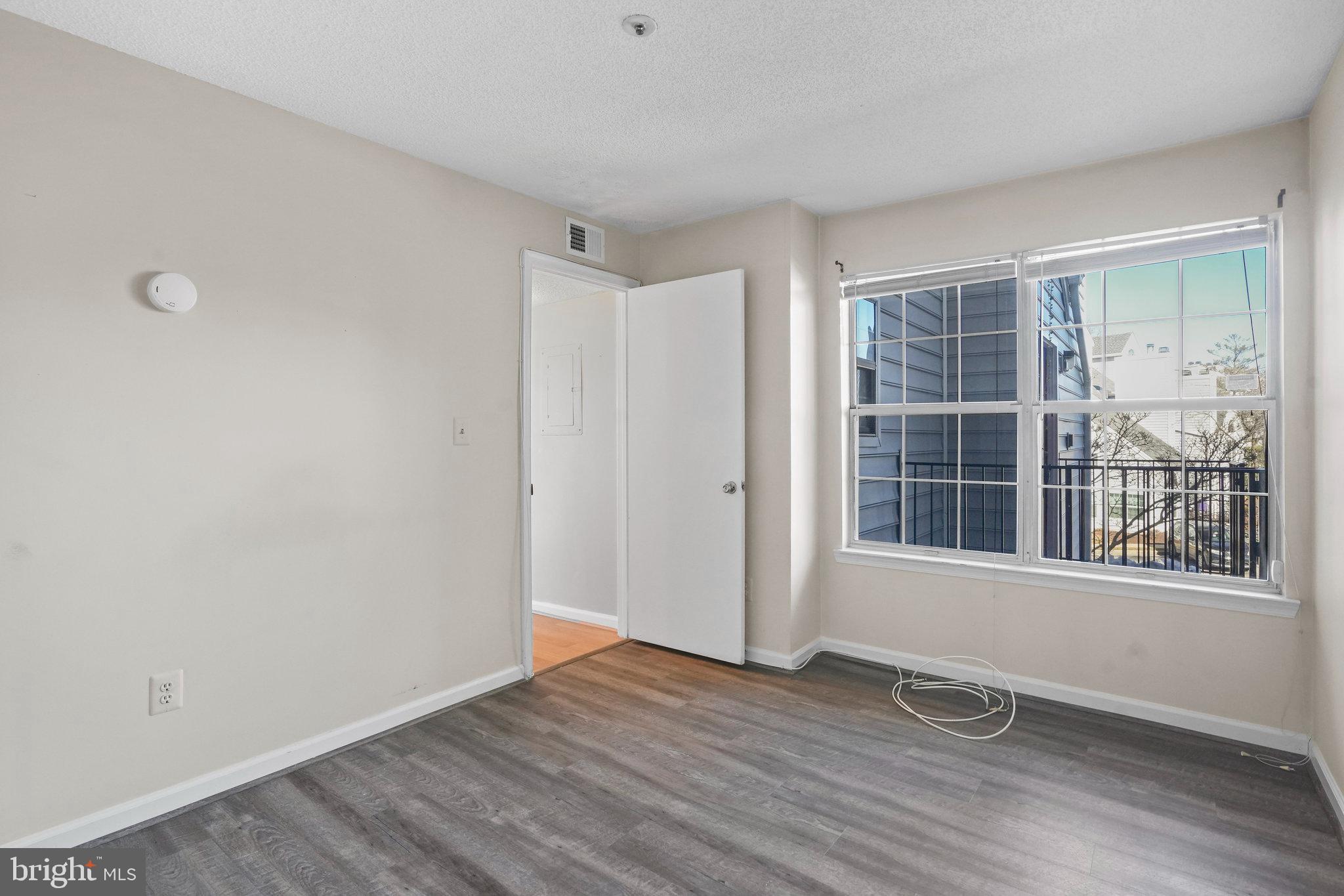 14023 Vista Drive, Unit 89 Laurel, MD 20707 - Photo 15 of 26 a view of an empty room with wooden floor and windows