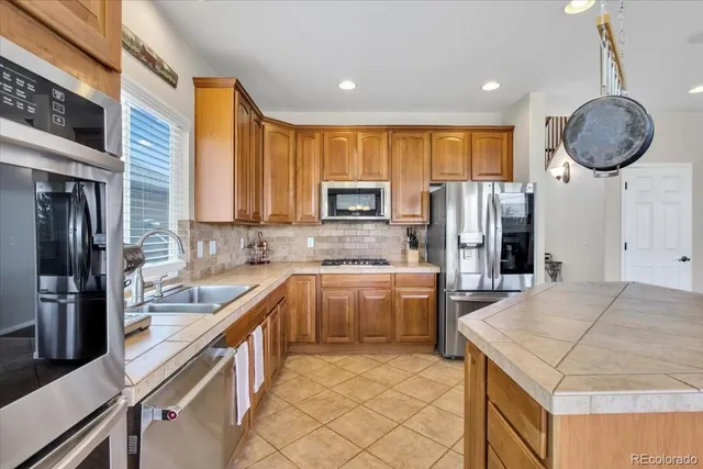 a kitchen with a sink a refrigerator and a stove top oven