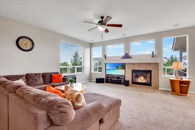 a living room with furniture a fireplace and a large window