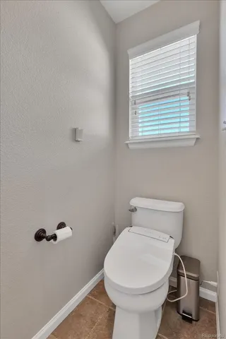 a bathroom with a toilet and a window
