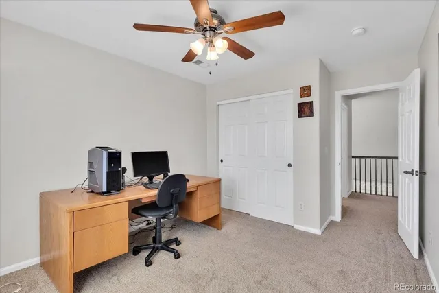 a view of a workspace with furniture and a window