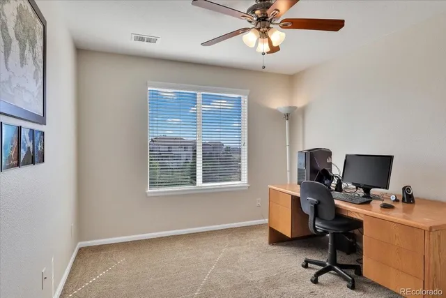 a view of a workspace with furniture and a window