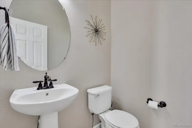 a bathroom with a sink a toilet and mirror