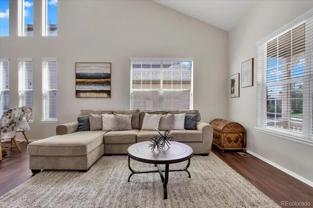 a living room with furniture a large window and a table