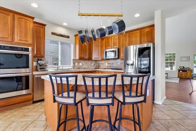 a kitchen with stainless steel appliances granite countertop a stove top oven a sink and a microwave