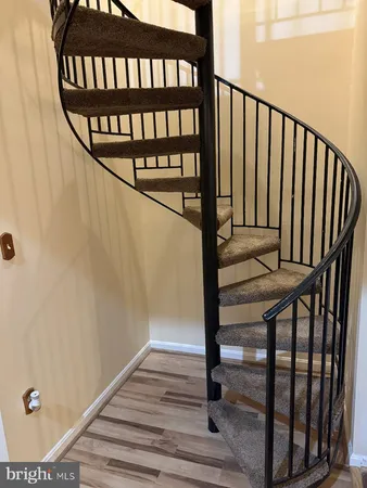 a view of staircase with railing and white walls