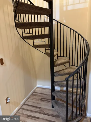a view of staircase with railing and white walls