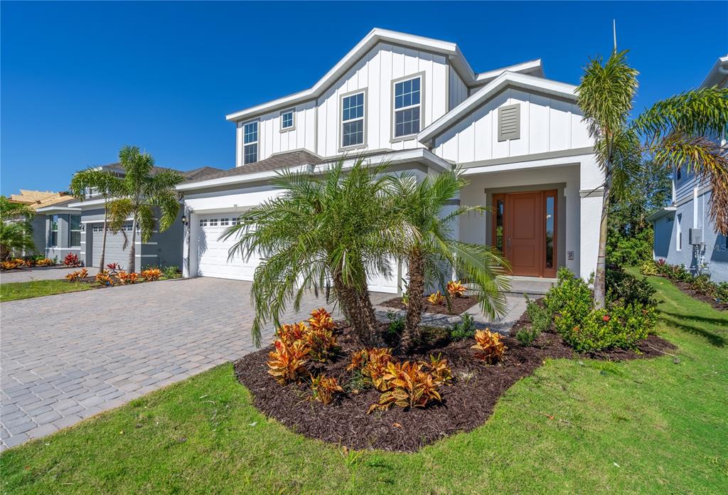 a front view of a house with a garden and plants