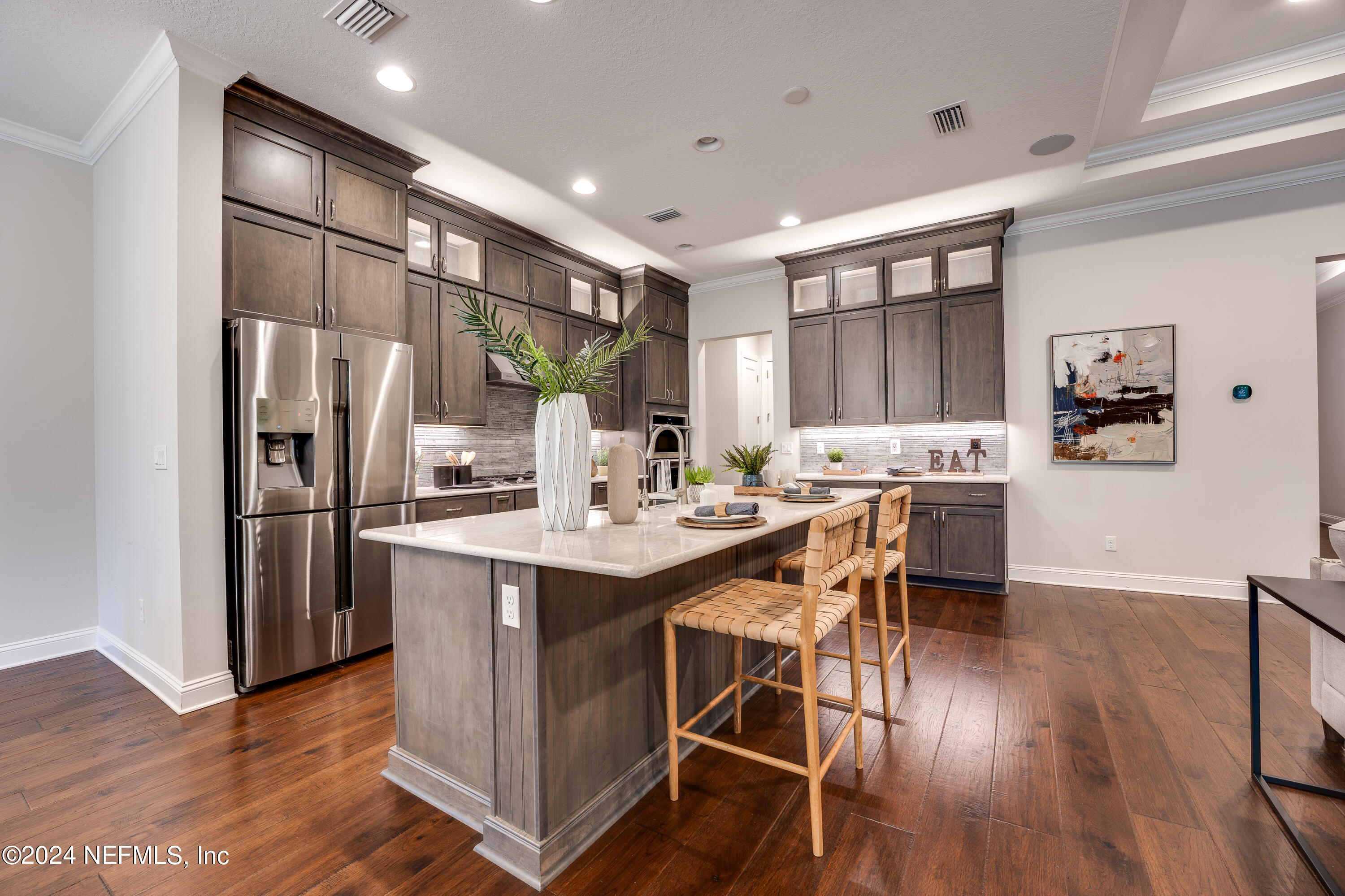 257 Glenneyre Circle St. Augustine, FL 32092 - Photo 15 of 98 a kitchen with stainless steel appliances kitchen island granite countertop a refrigerator a stove a sink a dining table and chairs with wooden floor