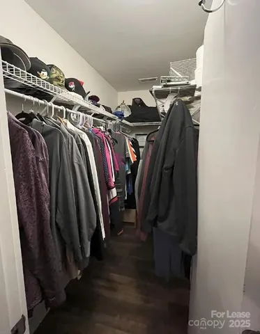 a view of walk in closet with clothes and shoes