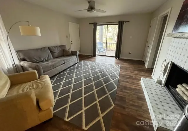 a living room with furniture a flat screen tv and a fireplace