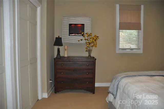 a bedroom with a bed and a flat tv screen on a dresser