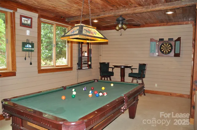 a room with pool table and windows