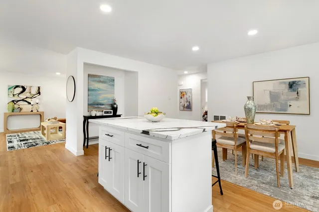 a kitchen with a dining table chairs refrigerator and cabinets