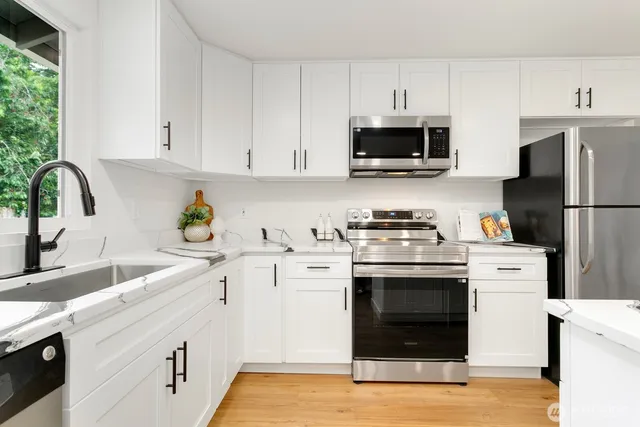 a kitchen with cabinets stainless steel appliances a sink and a counter space