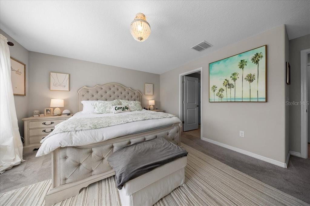 9329 Southwest 57th Terrace Ocala, FL 34476 - Photo 27 of 64 a bedroom with a bed and a painting on the wall